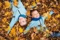 Kids laying on fallen leaves in autumn park Royalty Free Stock Photo