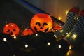 Kids legs in bright colorful striped funny socks in garland lights on floor with pumpkins in room.