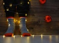 Kids legs in bright colorful striped funny socks in garland lights on floor with pumpkins in room.
