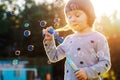 Kids little girl blowing bubbles on the Playground with sunset background Royalty Free Stock Photo