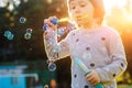 Kids little girl blowing bubbles on the Playground with sunset background Royalty Free Stock Photo