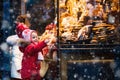 Kids looking at candy and pastry on Christmas market