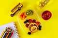 Kids lunch box with pancake, berries and apple on yellow background