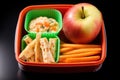 kids lunchbox with small ice-cream cone, carrot sticks, and apple slices