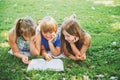 Kids lying on green grass and reading story book Royalty Free Stock Photo