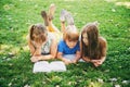 Kids lying on green grass and reading story book Royalty Free Stock Photo