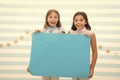 Kids make advertisement. advertising your product. smiling little girls kids hold blue advertisement poster for copy Royalty Free Stock Photo