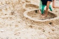 Kids making sand castle on the beach. Happy family and children playing on the sand, making walls of sandcastle near sea. Summer Royalty Free Stock Photo