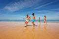 Kids in the middle of soccer game play on a beach Royalty Free Stock Photo