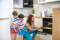 Kids and mother baking. Two children and parent cooking. Little boy and brother boy cook and bake in a white kitchen with modern Royalty Free Stock Photo