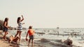 Kids and mother on beach have fun with swan.