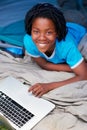 Kids are never far from the laptops. A young boy using his laptop while away on a camping trip. Royalty Free Stock Photo