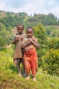 Kids in old ragged clothes in a rural area, eating candy, Lake Mutanda, Uganda.