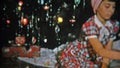 1951: Kids opening Christmas gifts in front of festive tree. NEWARK, NEW JERSEY