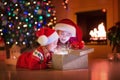 Kids opening Christmas presents at fireplace Royalty Free Stock Photo