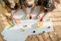 Kids painting on paper with while lying on floor at home