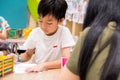 Kids are painting picture with color pencil with their teacher in the classroom to learn paint skill. they are practicing the Royalty Free Stock Photo