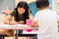 Kids are painting picture with color pencil with their teacher in the classroom to learn paint skill. they are practicing the Royalty Free Stock Photo