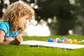 Kids painting in spring nature. Child boy painting with paints color and brush in park outdoor. Royalty Free Stock Photo