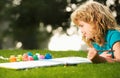 Kids painting in spring nature. Child boy painting with paints color and brush in park outdoor. Royalty Free Stock Photo