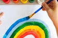 Kids painting watercolor rainbows at table at home. Arts and crafts. Royalty Free Stock Photo