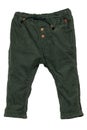 Kids pants isolated. Close-up of a stylish fashionable dark green corduroy trousers with ribbon bow for the little boy. Childrens