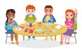 Kids paper craft. Boys and girls cut colored paper figures at round table, make applications, origami flags and chains Royalty Free Stock Photo