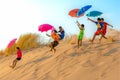 KIDS PARACHUTING OFF SAND DUNES WITH UMBRELLAS