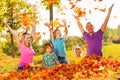 Kids and parents throw leaves in the air sitting Royalty Free Stock Photo