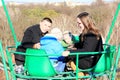 Kids with parents on a viewing car in an amusement park in the early spring