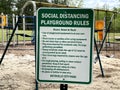 Kids park covid-19 social distancing rules sign and playground