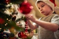 A little boy decorating a Christmas tree with his mother at home. Together, New Year, family, celebration Royalty Free Stock Photo