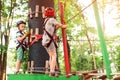 Young brothers climbing in high rope course in adventure park. Children in forest adventure park