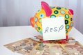 Kids piggy bank with one hundred dollars and RESP sticky note Royalty Free Stock Photo