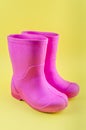 Kids pink rubber boots EVA on a yellow background Royalty Free Stock Photo