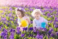 Kids plant and water flowers in spring garden