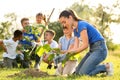 Kids planting trees with volunteers