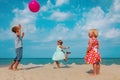 Kids- boy and girls- play with ball on beach vacation Royalty Free Stock Photo