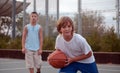 Kids play basketball in a school.