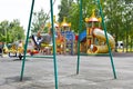 Kids play on a children`s playground in city park in summer. Royalty Free Stock Photo