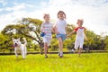 Kids play with dog. Children and puppy run in park Royalty Free Stock Photo