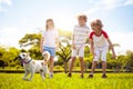 Kids play with dog. Children and puppy run in park Royalty Free Stock Photo