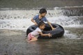 a kids play and lying on a tire floating in water Filmed in Chiang mai, Thailand