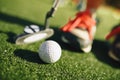 Kids play mini-golf. Close-up image of the player in snickers with a mini golf club