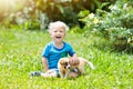 Kids play with puppy. Children and dog in garden. Royalty Free Stock Photo