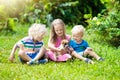 Kids play with puppy. Children and dog in garden.