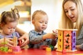Kids play with shapes and colorful wooden puzzle in a montessori classroom