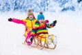 Kids play in snow. Winter sleigh ride for children Royalty Free Stock Photo