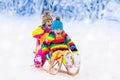 Kids play in snow. Winter sleigh ride for children Royalty Free Stock Photo