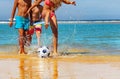 Kids play soccer on the beach near water closeup Royalty Free Stock Photo